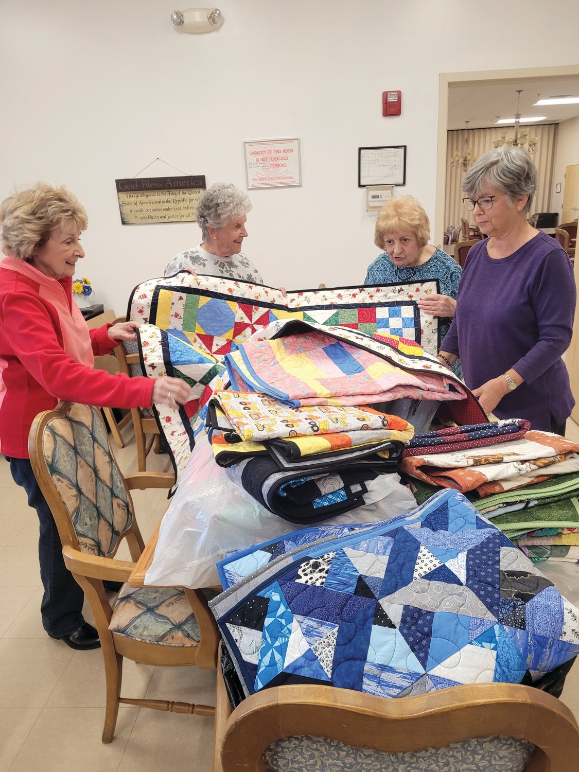 KEEP WARM: Members of the Giving Quilt Group at the Johnston Senior Center, from left to right, Betty Bryda, Evelyn Cedroni, Marie Lanzi and Fran Zanni prepare their quilts, which have been donated to Children’s Friend and Services, for families in need.